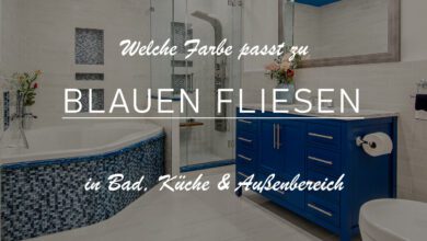 Einblick in ein großes Badezimmer mit weißen und blauen Akzenten. Der Boden und die Wände sind in einem weiß-grau hellen Ton gehalten. Die Möbel, wie beispielsweise der Badezimmerschrank in einem satten Blauton. Die Badewanne hat ein detailliertes Mosaik von blauen Fliesen.